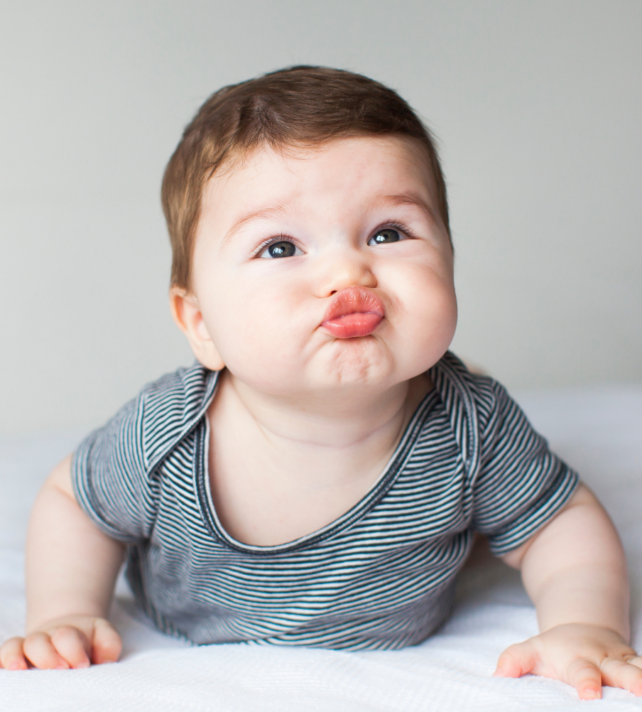 Baby pouting while lying down, representing unsettled baby sleep moments.